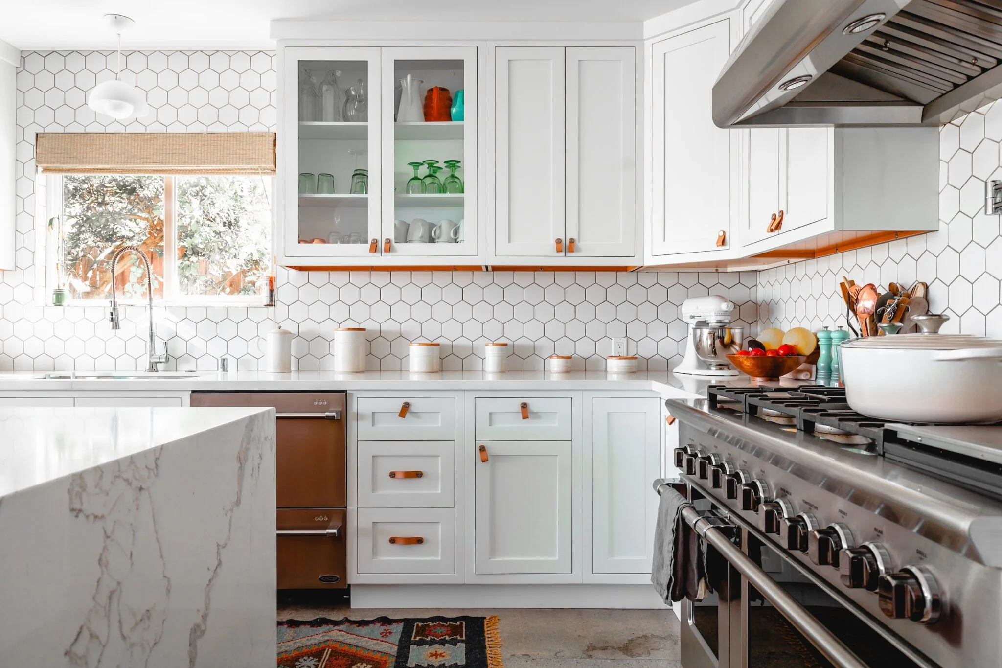 A contemporary kitchen showcasing white cabinets paired with warm copper highlights.