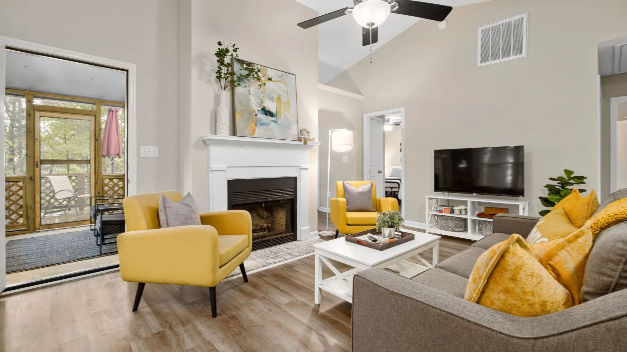 A remodeled living room featuring yellow chairs and a cozy fireplace, creating a warm and inviting atmosphere.