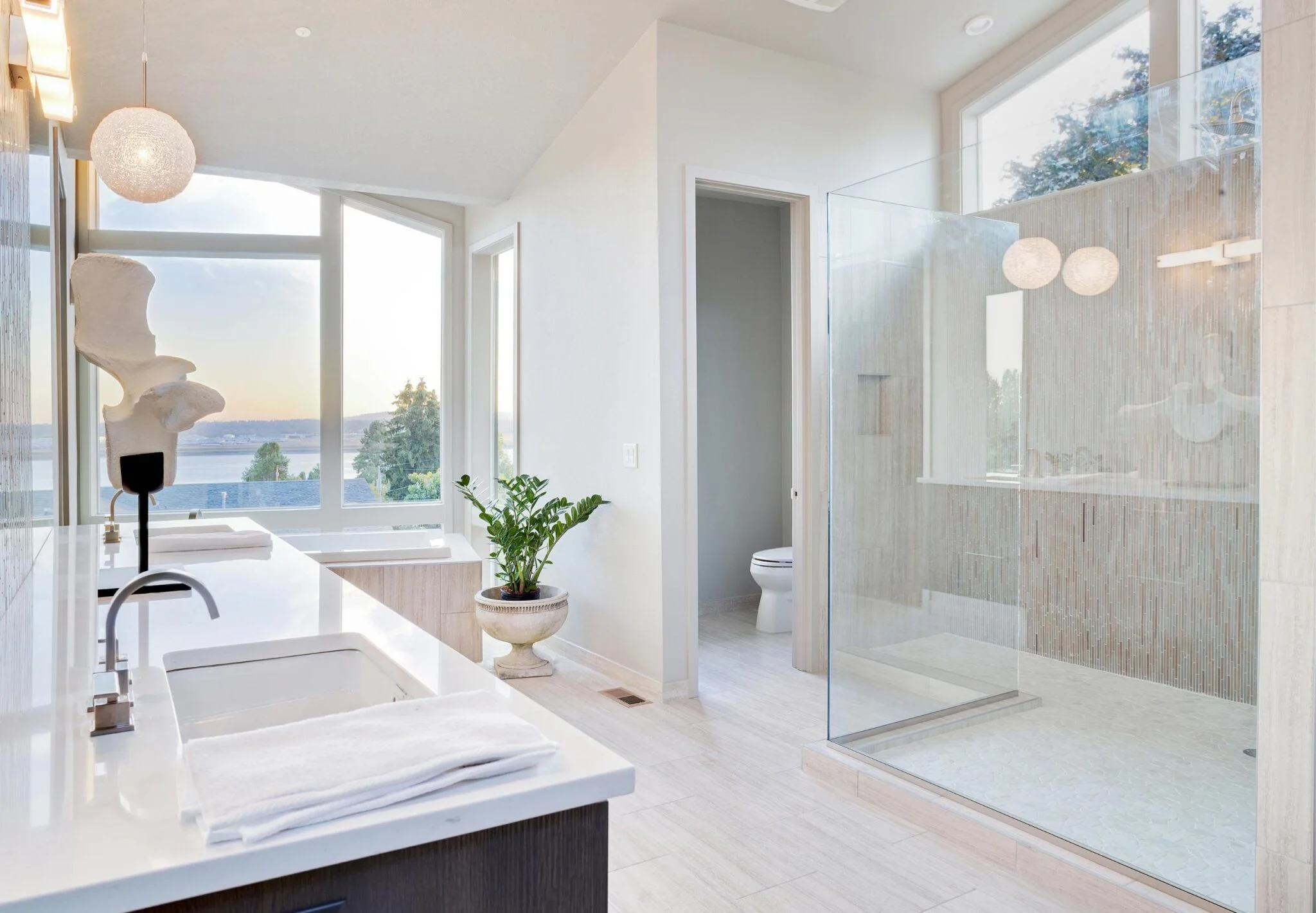 A large, well-lit bathroom showcasing a sleek glass shower door and contemporary design elements.