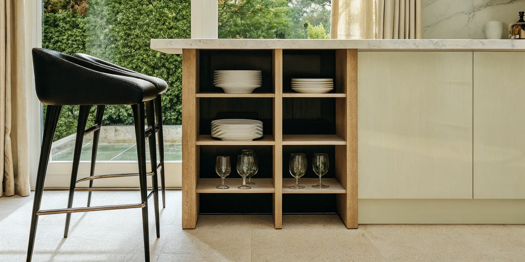 Kitchen island with built-in seating and open shelving for storage.